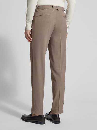 Męski model nosi Slim Fit Stoffhose mit Viskose-Anteil od Lindbergh w kolorze beżowym, kanty, wpuszczane kieszenie, zapięcie na haftkę i zamek błyskawiczny, elastyczna mieszanka materiałów, szerokość w rozmiarze M: 37 cm, długość wewnętrzna nogawki: 80 cm, widok całej sylwetki od tyłu