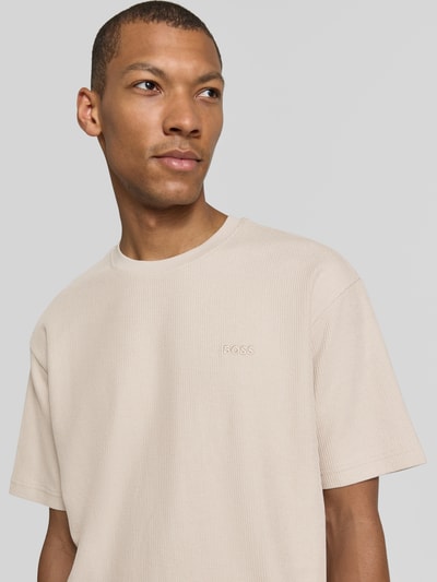 Männermodel trägt Regular Fit T-Shirt aus reiner Baumwolle Modell 'Te_Rib' von BOSS für BOSS Orange in Beige, Nahaufnahme Oberkörper.
