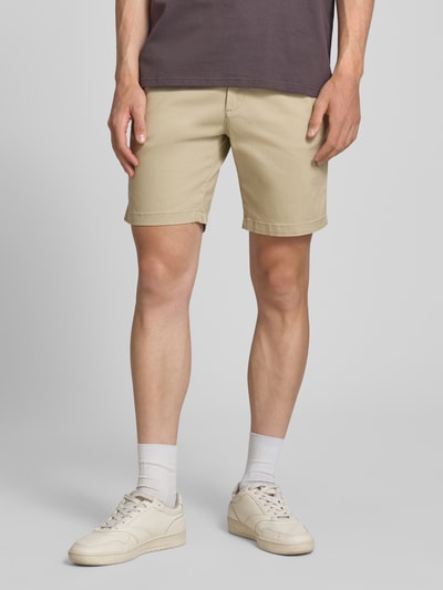 Männermodel trägt gerade, beigefarbene Straight Fit Shorts mit abnehmbarem Gürtel Modell 'Adam' von Jack & Jones, elastischer Baumwoll-Mix, Eingriff- und Gesäßtaschen, Knopf- und Reißverschluss, Ganzkörperansicht von vorne.