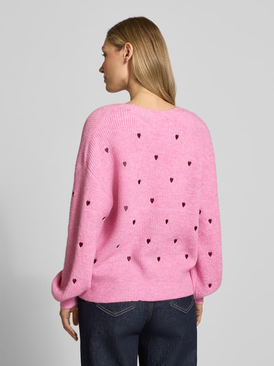 Vrouwenmodel draagt Regular Fit Cardigan met Escorial wol-aandeel model 'Fleur' van YAS in roze met all-over motiefstitching, tricotlook, V-hals en knoopsluiting, elastische materiaalmix, ruglengte maat S 56 cm, mouwlengte 57 cm. Ganzkörperansicht Rückansicht.