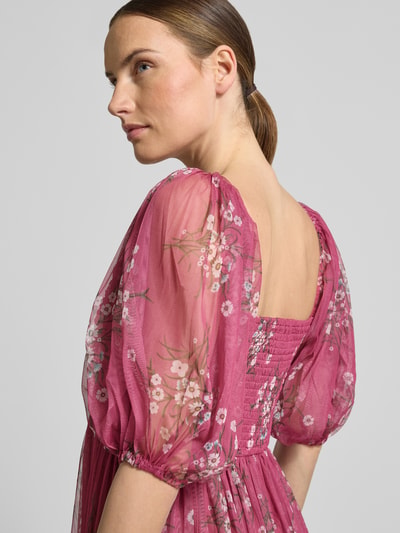 Modelka prezentuje sukienkę koktajlową 'Cocktailkleid im Allover-Look' od LACE & BEADS, tiul, linia a, sukienka midi, wzór na całej powierzchni, bufiaste rękawy, długość tyłu w rozmiarze s: 108 cm, szerokość w rozmiarze s: 35 cm, długość rękawów w rozmiarze s: 36 cm; różowe odcienie, kwiatowy wzór, tekstura tiulu, zbliżenie na górną część ciała, widok z przodu.