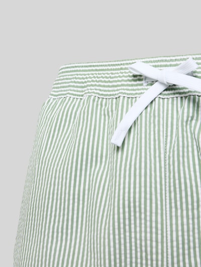Produktfoto, Badeshorts aus Baumwoll-Mix von Lacoste, grün-weiß gestreift, Seersucker-Textur, elastischer Bund mit Tunnelzug und Logo-Applikation.