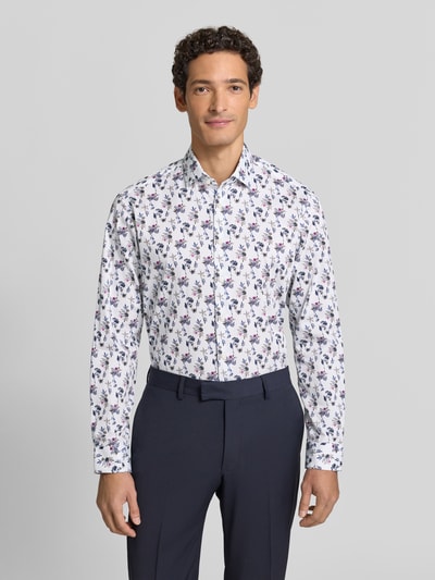 Männermodel trägt Regular Fit Businesshemd aus reiner Baumwolle mit floralem Muster von Christian Berg Men, Ganzkörperansicht von vorne. Rückenlänge 75 cm, Schulterbreite 41 cm, Ärmellänge 65 cm, Kentkragen, weiß mit buntem Floralmuster.