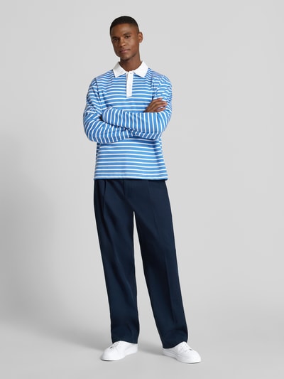 Męskimodel nosi Koszulkę polo z mieszanki bawełny i wiskozy model 'PERSSON' od Casual Friday, krój relaxed fit, listwa guzikowa, z długim rękawem, długość tyłu 66 cm dla rozmiaru M, stylizacje casualowe, pełen widok z przodu.