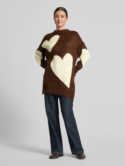 Kobiece model prezentuje Sweter z dzianiny 'Strickpullover aus Alpaka-Mix' od miss goodlife w brązowo-kremowych kolorach z dużymi sercami, mieszanka wełny z alpaki i bawełny, luźny krój, prążkowana stójka i wykończenia, długość tyłu 73 cm, długość rękawów 47 cm, widok całej sylwetki z przodu.