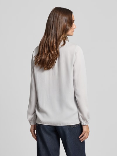 Männermodel trägt Regular Fit Bluse mit V-Ausschnitt od Marc Cain, krój regular fit, dekolt w serek, detal z logo, długość tyłu 65 cm, długość rękawów 59 cm, rozmiar 36, jasnoszara, prosta faktura, Ganzkörperansicht Rückansicht.