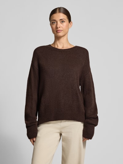 Vrouwenmodel draagt Oversized Fit Strickpullover mit Rundhalsausschnitt van Milano Italy in donkerbruin, geribde boorden, lange mouwen, gebreide look, elastische materiaalmix, detailafwerking, vooraanzicht bovenlichaam.