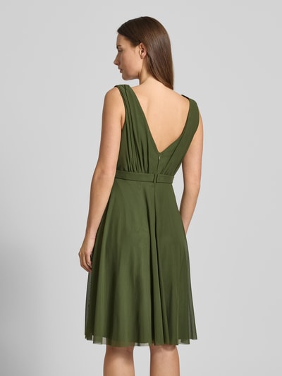 Vrouwenmodel draagt Cocktailkleid mit V-Ausschnitt van TROYDEN COLLECTION, groen, taille ceintuur, naadrits, ruglengte 79 cm, Ganzkörperansicht Rückansicht.