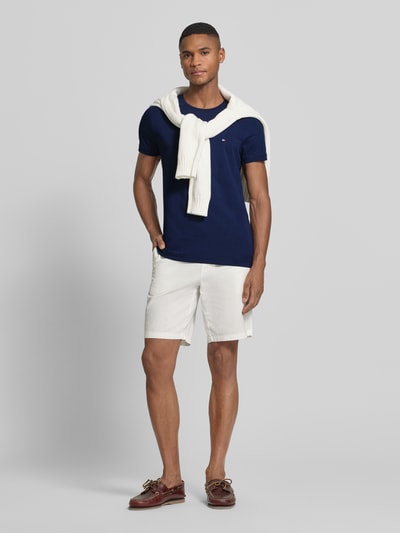Männermodel trägt Slim Fit T-Shirt aus Baumwoll-Mix von Tommy Hilfiger in Optik: Unifarben mit Logo-Detail, Rundhals, Kurzarm, Stretch, Ganzkörperansicht von vorne.