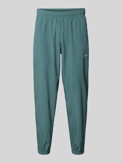 Produktfoto, Form Pants mit Logo-Print und Eingrifftaschen von NIKE TRAINING in Türkis, körpernaher Schnitt, elastischer Bund, elastische Abschlüsse.