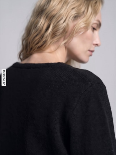 Frauenmodel trägt Relaxed Fit Strickjacke mit Wool-Anteil Modell 'LIVA' von ONLY, schwarze grobe Stricktextur, Nahaufnahme Oberkörper, Damen Strickjacke von ONLY, KI-modifiziertes Bild.