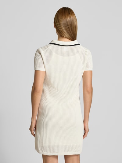 Frauenmodel trägt Slim Fit Minikleid aus reiner Baumwolle Modell 'SLYSY' von HUGO, Two-Tone-Optik, Strick, Kontraststreifen, Ganzkörperansicht Rückansicht.