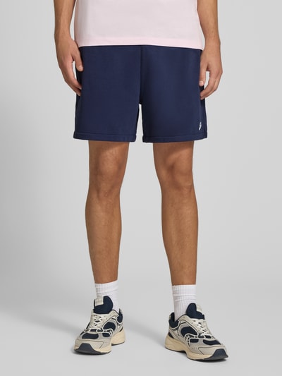 Männermodel trägt Regular Fit Sweatshorts aus Baumwoll-Mix von Nike in Dunkelblau, glatte Textur, Herren Sweatshorts, Nahaufnahme Unterkörper.
