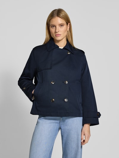 Frauenmodel trägt Trenchcoat in kurzem Design mit Baumwoll-Anteil von Jake*s Casual in Dunkelblau, doppelreihig, gerade Passform, Umlegekragen, Eingrifftaschen, Schulter- und Ärmelriegel, Material-Mix, Ganzkörperansicht von vorne.