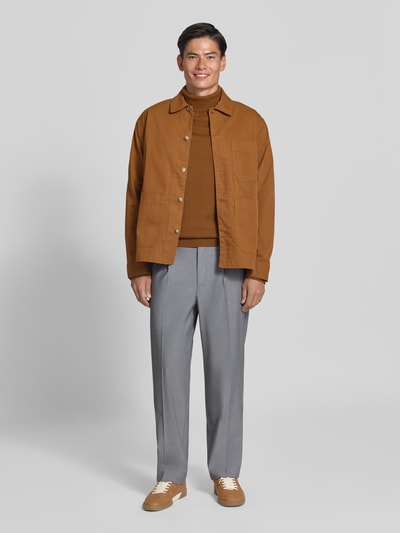Männermodel trägt Straight Fit Hose mit Viskose-Anteil von MCNEAL, Bundfalten, grau, Kombination mit brauner Jacke, Ganzkörperansicht von vorne.