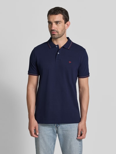 Mannenmodel draagt Regular Fit poloshirt met labelstitching van Fynch-Hatton, puur katoen, knoopsluiting, ruglengte maat M 73 cm. Ganzkörperansicht von voren.
