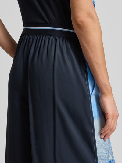 Frauenmodel trägt Wide Fit Stoffhose aus reinem Lyocell von Marc Cain, dunkelblau, Allover-Motiv-Print, elastischer Bund, Detailaufnahme.