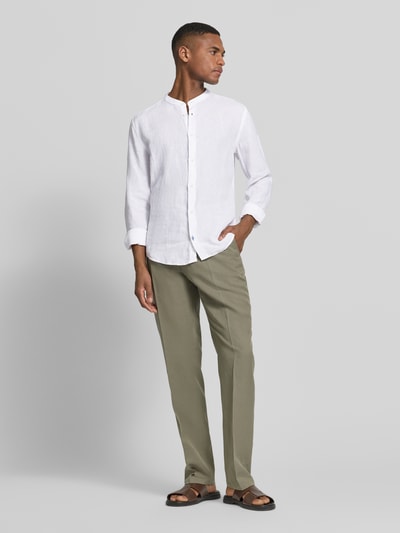 Männermodel trägt Slim Fit Leinenhemd aus reinen Leinen mit Stehkragen von OLYMP Level Five, weiß, Langärmelig, Ganzkörperansicht von vorne. Rückenlänge 75 cm, Schulterbreite 48 cm, Ärmellänge 64 cm, Knopfleiste, Sportmanschetten.