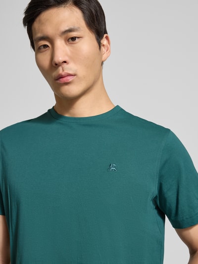 Männermodel trägt T-Shirt mit Rundhalsausschnitt und Logo-Stitching von Lerros in grün, reine Baumwolle, gerader Schnitt, Nahaufnahme Oberkörper.