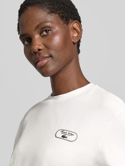 Vrouwenmodel draagt Regular Fit T-Shirt aus Baumwoll-Mix van Lacoste, look: effen, korte lengte, labelprint, logostitching, ronde hals, korte mouw, jerseymateriaal, katoenmix, close-up bovenlichaam.