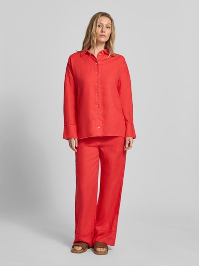 Frauenmodel trägt Regular Fit Hemdbluse aus reinen Leinen von Christian Berg Woman in kräftigem Rot mit Knopfleiste und Fransenbesatz, Ganzkörperansicht von vorne. Rückenlänge bei Größe 36: 72 cm, Ärmellänge 55 cm, Hemdblusenkragen, Langärmeliges Design.