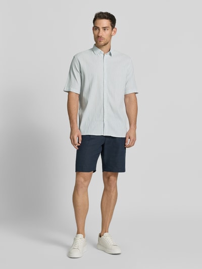 Männermodel trägt Comfort Fit Freizeithemd aus Lyocell-Baumwoll-Mix von Tom Tailor in Unifarbe mit Kentkragen, Ganzkörperansicht von vorne.