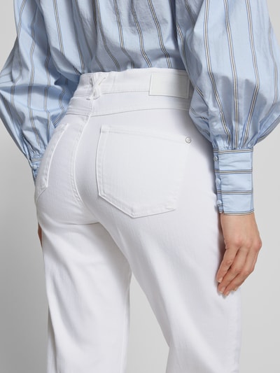 Männermodel trägt białe Slim Fit Jeans mit fixierten Beinabschlüssen Modell 'Darleen' von Angels, elastyczny materiał, 5 kieszeni, szerokość w rozmiarze 36/30: 40 cm, długość nogawki 69 cm, zbliżenie na tył.