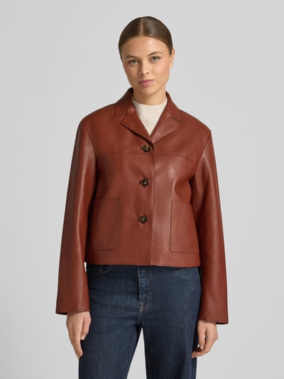 Frauenmodel trägt Jacke in Leder-Optik Modell 'SABI' von Mango, Regular-Fit, Reverskragen, Knopfleiste, Eingrifftaschen, braun, Ganzkörperansicht von vorne.