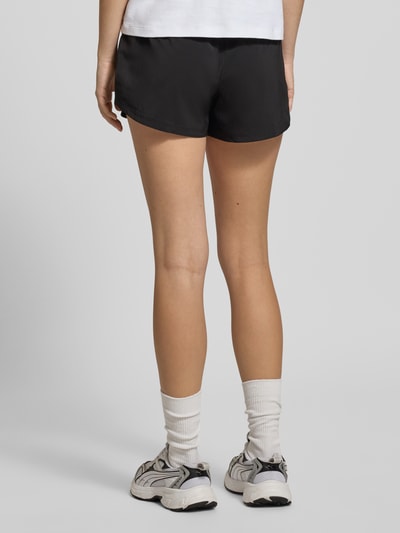 Frauenmodel trägt Regular Fit Shorts mit elastischem Bund von PUMA, schwarze Farbe, ausgestellte Passform, Rückansicht Ganzkörperansicht.