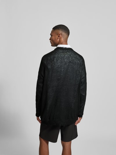 Männermodel trägt Relaxed Fit Longsleeve mit Mohair-Anteil von MM6 Maison Margiela in Schwarz, Strick-Optik, Rückenansicht Ganzkörperansicht.