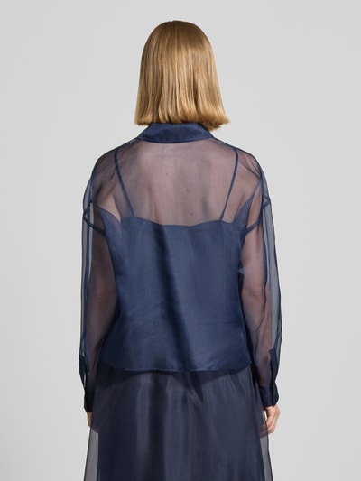 Frauenmodel trägt Boxy Fit Langarmbluse aus semitransparenter Seide Modell 'COLOMBIA' von Weekend Max Mara in Dunkelblau, semitransparente Optik, Hemdblusenkragen, separatem blickdichtem Trägertop aus reiner Baumwolle, mit Knopfleiste und Manschetten, Ganzkörperansicht Rückansicht.
