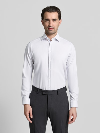 Mężczyzna nosi Regular Fit Business Hemd aus Baumwolle mit Kentkragen od Christian Berg Men, biała bawełna, krój regular fit, z listwą guzikową, długość pleców w rozmiarze 39/40: 78 cm, szerokość ramion w rozmiarze 39/40: 47 cm, długość rękawa w rozmiarze 39/40: 64 cm, całopostaciowy widok z przodu.