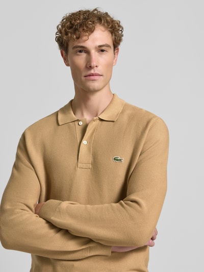 Męski model nosi Regular Fit Poloshirt aus reiner Baumwolle von Lacoste w kolorze beżowym, gładka tekstura, zbliżenie na górną część ciała