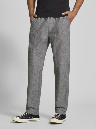 Mannelijk model draagt Regular Fit wijdte broek uit mix van katoen en linnen van Tommy Jeans, gemêleerde look, steekzakken, boord met tunnelkoord, labelstitching, mix van gevlamd garen, materiaalverwerking, zij- en achterzakken, elastische boord, kleur grijs, full body aanzicht van voren.
