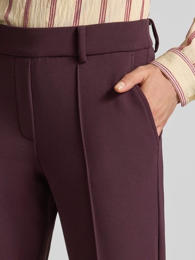 Kobiece model prezentuje spodnie Regular Fit z elastycznym pasem model 'FRANCOISE' od CAMBIO w kolorze głębokiego bordo, tekstura gładka, detal zbliżeniowy, kontekst: damskie szerokie spodnie od CAMBIO