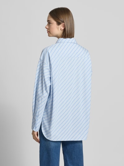 Frauenmodel trägt Relaxed Fit Bluse mit Brusttasche von JJXX, Damen Bluse aus Reine Baumwolle, Modell JAMIE, Hemdblusenkragen, Rückenlänge 78 cm, Ärmellänge 60 cm, Ganzkörperansicht Rückansicht.
