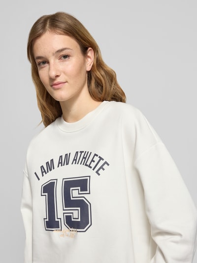 Vrouwenmodel draagt Relaxed Fit Sweatshirt uit zuivere katoen van Marc O'Polo Denim, wit, unicolor, label stitching, motiefprint, crew neck, lange mouwen, geribde boorden, sweatstof, vooraanzicht van het bovenlichaam.