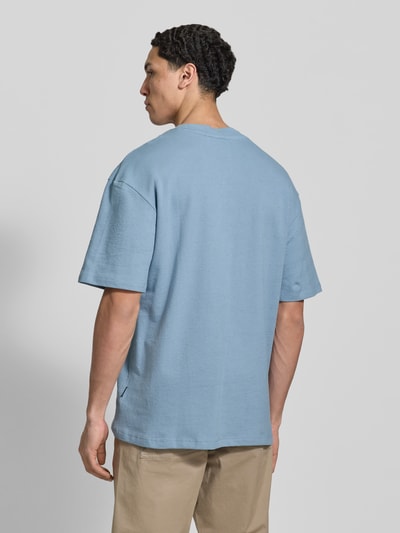 Męski model nosi T-shirt z okrągłym dekoltem Modell 'KAISER' od Blend, czysta bawełna, krój relaxed fit, długość tyłu w rozmiarze M: 73 cm, jasnoniebieski, gładka faktura, widok całej sylwetki z tyłu.