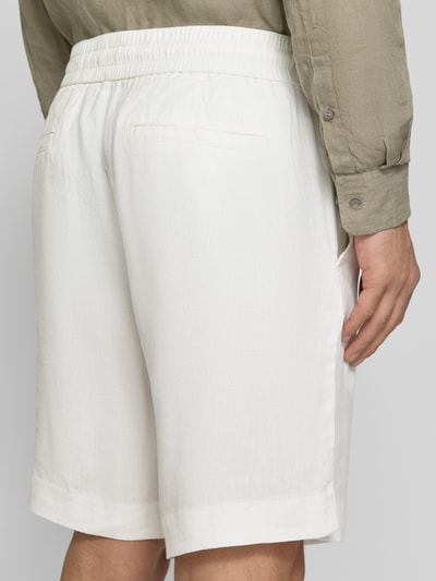 Męski model nosi Straight Fit Chinoshorts aus Leinen-Lyocell-Mix Modell 'CINO' od HUGO, gładki materiał flammgarn, elastyczny pas, kieszenie, widok całych pleców