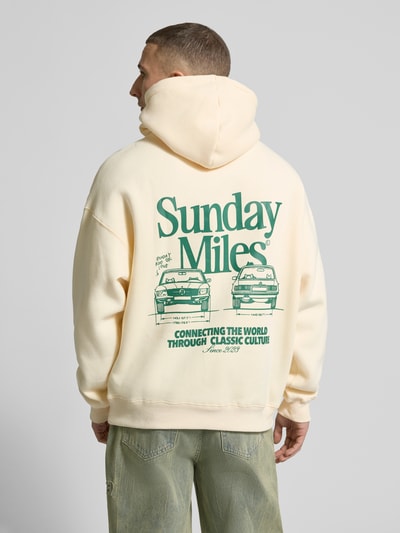 Männermodel trägt Hoodie mit Logo-Prints Modell 'Sunday Miles' von ANOTHER COTTON LAB in Creme und Grün, Baumwoll-Mix, Rückenansicht
