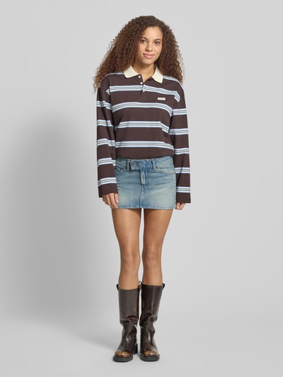 Modelka nosi Jeansrock im Used-Look mit Eingrifftaschen von Levi's®, jasnoniebieski, prosty krój, mini, bawełna, z kieszeniami, Szerokość w rozmiarze 27: 40 cm, długość całkowita: 30 cm, tekstura denimu, widok całej sylwetki z przodu.