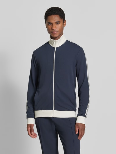 Männermodel trägt Slim Fit Sweatjacke mit Strukturmuster von MCNEAL in Dunkelblau mit weißen Details, elastischer Material-Mix, Ganzkörperansicht von vorne.