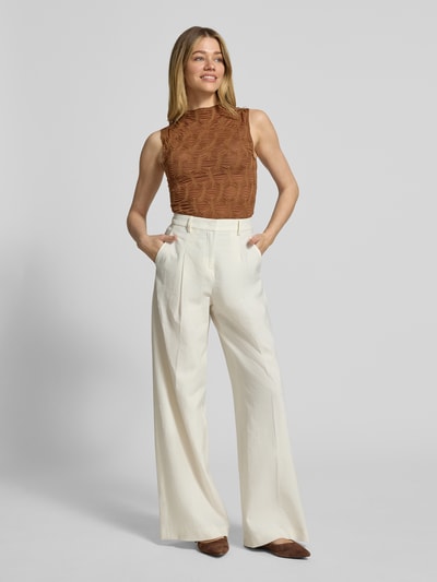 Modelka nosi Top mit Strukturmuster und Rundhalsausschnitt od Rich & Royal, brązowy wzór, strukturalna faktura, dopasowany krój, mieszanka materiałów ze stretchem, okrągły dekolt, długość pleców w rozmiarze S: 64 cm, całopostaciowy widok z przodu