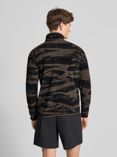 Männermodel trägt Fleecepullover mit Troyer-Kragen von The North Face in Schwarz-Oliv mit lockerem Schnitt, Rückansicht, Ganzkörperansicht.