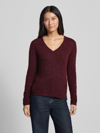 Frauenmodel trägt Slim Fit Strickpullover aus Material-Mix mit Woll-Anteil von MOS MOSH in Dunkelrot, V-Ausschnitt, Jeans, Ganzkörperansicht von vorne. Rückenlänge 60 cm, Ärmellänge 64 cm, elastische Abschlüsse.