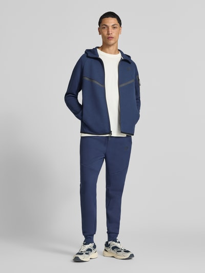 Męski model nosi Regular Fit Sweatjacke aus Baumwoll-Mix von Nike, kolor niebieski, gładka faktura, Ganzkörperansicht von vorne.