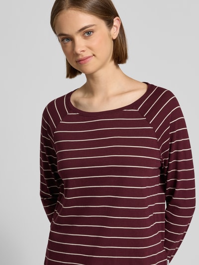 Frauenmodel trägt Regular Fit Langarmshirt aus reiner Baumwolle von Marc O'Polo DENIM in Bordeaux mit weißen Streifen, Nahaufnahme Oberkörper.
