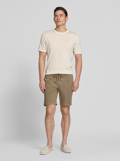 Männermodel trägt Straight Fit Shorts mit Bundfalten von Profuomo in Beige, elastischer Bund, Eingrifftaschen, Ganzkörperansicht von vorne.