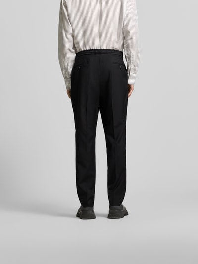 Männermodel trägt schwarze Straight Fit Stoffhose aus reiner Wolle von Officine Générale mit Bundfalten und Gesäßtaschen, Ganzkörperansicht Rückansicht.