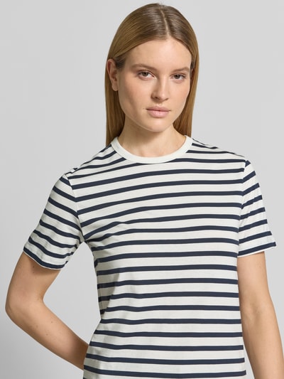 Modelka kobieca ma na sobie damski t-shirt z okrągłym dekoltem od Jake*s Casual, bawełna, prosty krój, rękaw o dł. 1/2, długość tyłu w rozmiarze S: 61 cm, biało-granatowe paski, faktura gładka. Zbliżenie na górną część ciała z przodu.